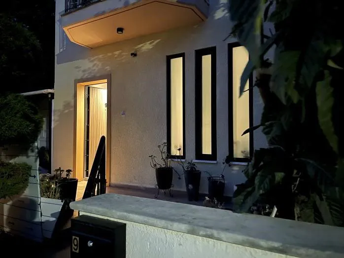 The house at night, with lit vertical windows