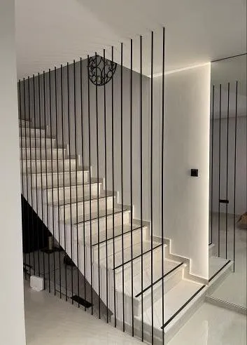 Lit staircase behind black vertical rods