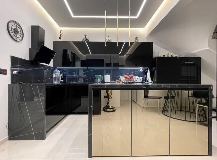 Black gloss kitchen under a lit ceiling