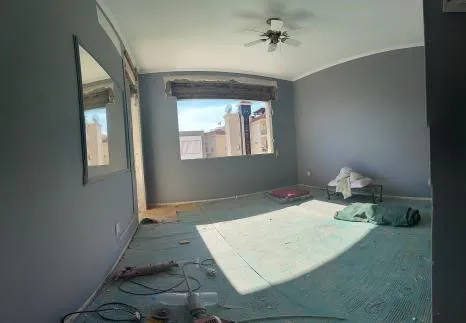 Empty room with a green carpet before demolition