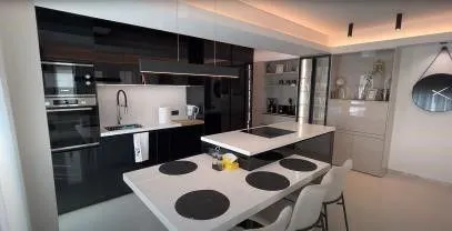Black gloss kitchen and a white dining table